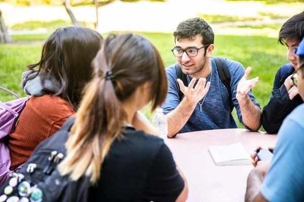 ein Mann mit Brille ist im Gespräch mit einer Jugendgruppe